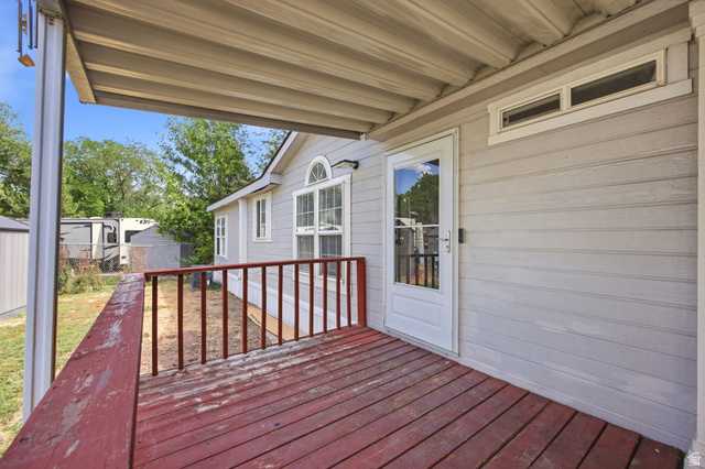 29 Grover Street Layton, UT 84041 - Photo 4 of 29 Covered porch featuring wood flooring and red railings