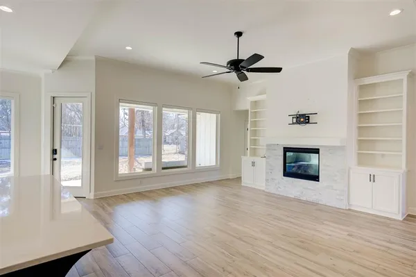 a view of an empty room with a fireplace and a window