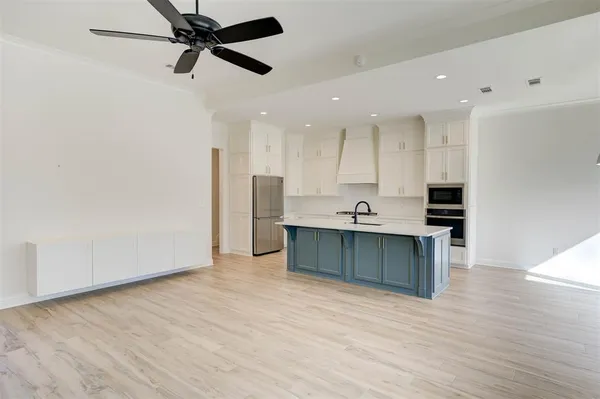 a view of kitchen with stainless steel appliances refrigerator stove microwave and cabinets