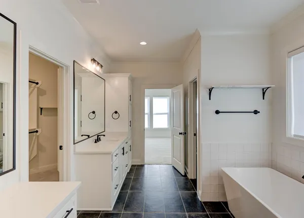 a bathroom with a tub shower sink and mirror
