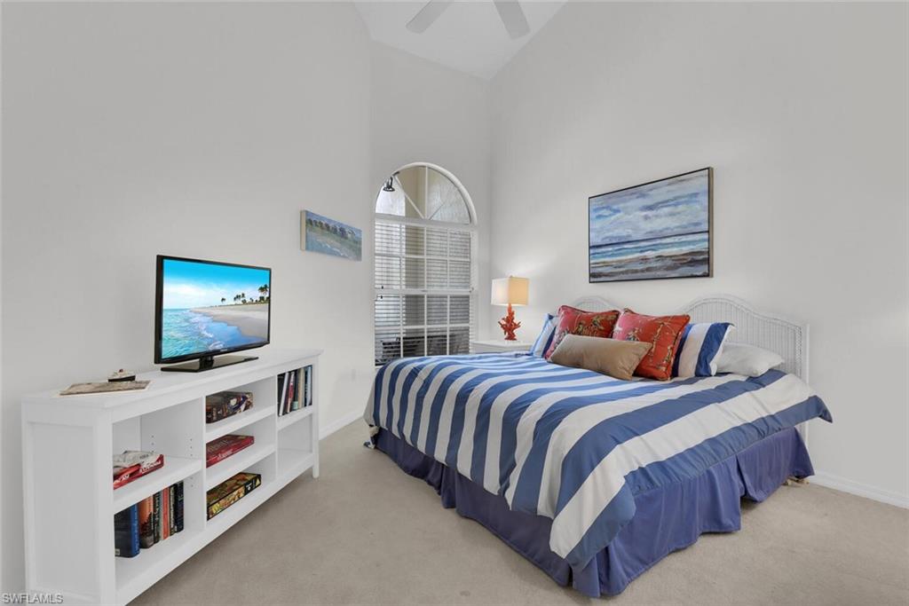 2124 Paget Circle, Unit 1 Naples, FL 34112 - Photo 13 of 31 a bedroom with a bed and a flat screen tv