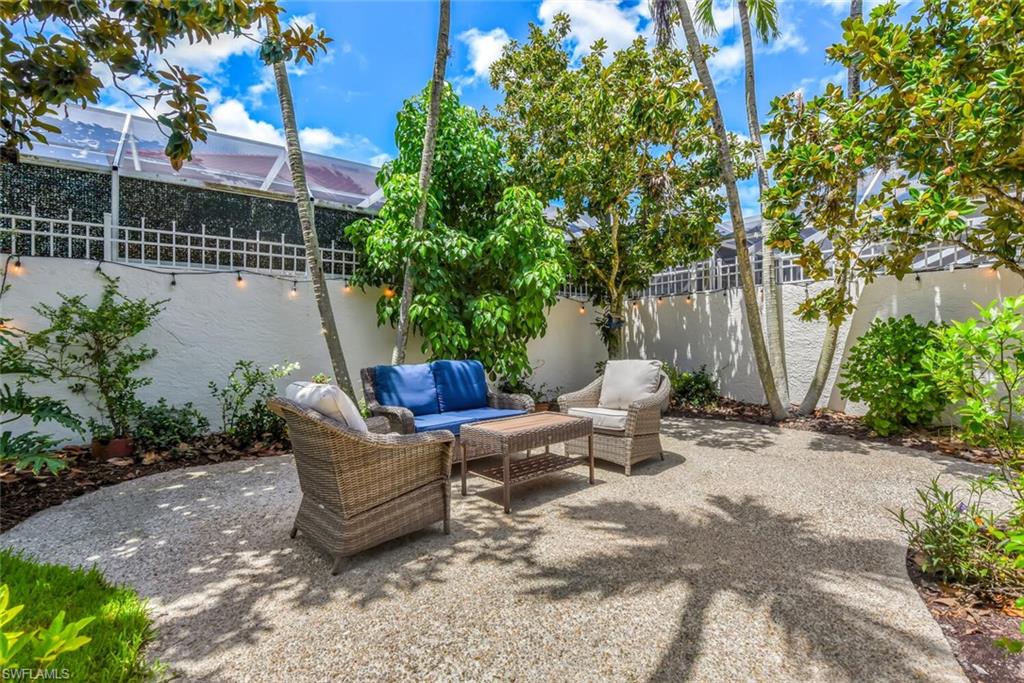 2124 Paget Circle, Unit 1 Naples, FL 34112 - Photo 20 of 31 a backyard of a house with table and chairs
