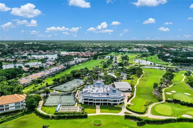 a view of a swimming pool with lawn chairs and plants