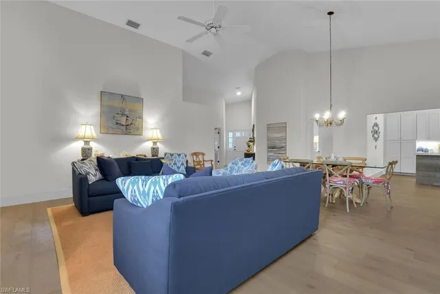 a living room with furniture a dining table and a chandelier