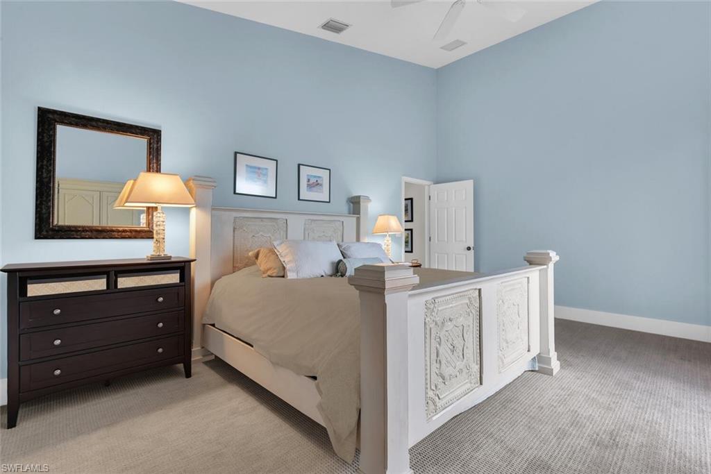 2124 Paget Circle, Unit 1 Naples, FL 34112 - Photo 9 of 31 a bed room with a bed and a lamp on dresser