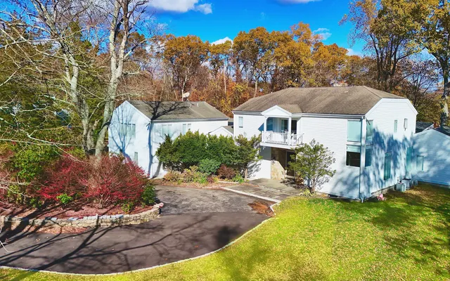 a front view of house with yard and trees in the background