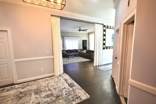 a view of a hallway view with wooden floor and living room