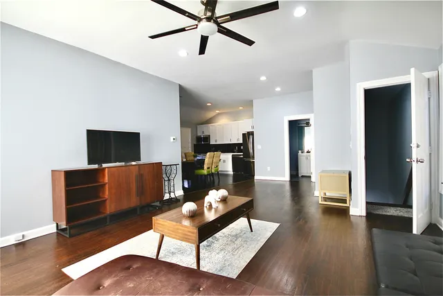 a living room with furniture and a view of kitchen