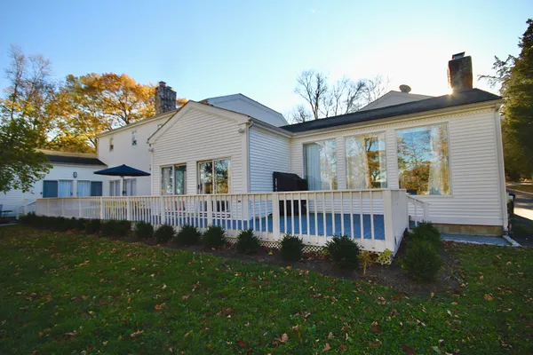 a view of a house with a yard and deck