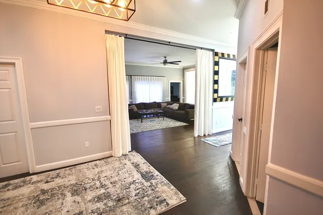 a view of a hallway view with wooden floor and living room