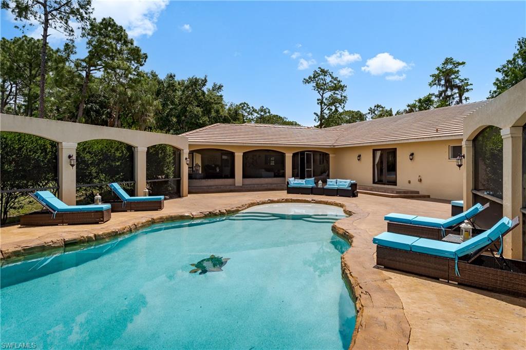 1781 21st Street Southwest Naples, FL 34117 - Photo 15 of 39 a front view of a house with swimming pool having outdoor seating