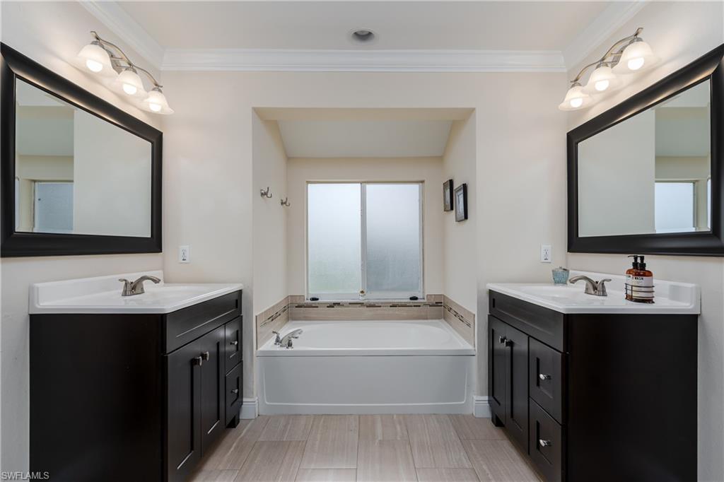 1781 21st Street Southwest Naples, FL 34117 - Photo 22 of 39 a bathroom with a tub a sink and mirror