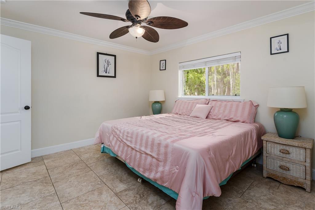 1781 21st Street Southwest Naples, FL 34117 - Photo 26 of 39 a bedroom with a bed and a chandelier