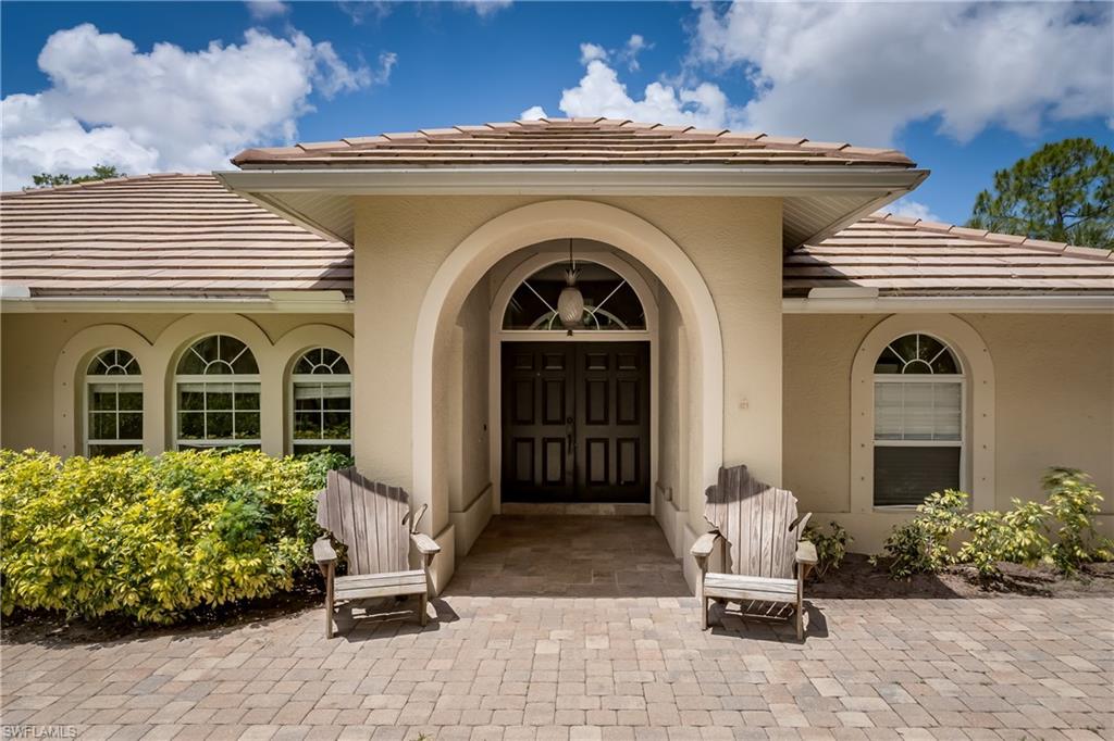 1781 21st Street Southwest Naples, FL 34117 - Photo 3 of 39 a front view of a house with garden
