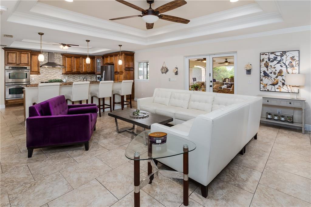1781 21st Street Southwest Naples, FL 34117 - Photo 9 of 39 a living room with furniture kitchen view and a chandelier