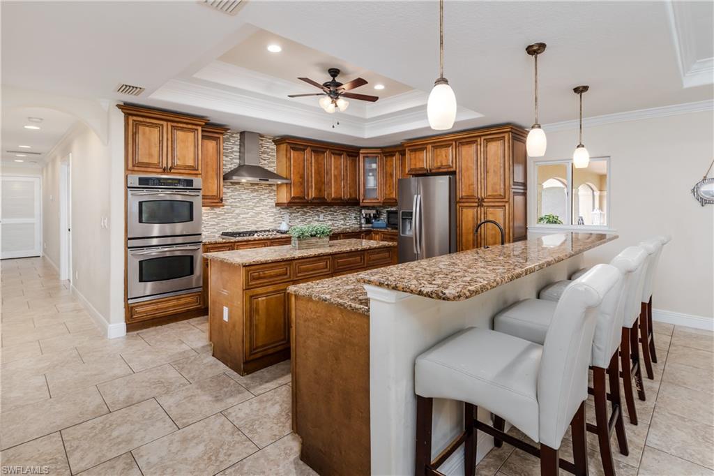 1781 21st Street Southwest Naples, FL 34117 - Photo 10 of 39 a kitchen with kitchen island granite countertop a stove a sink and a refrigerator