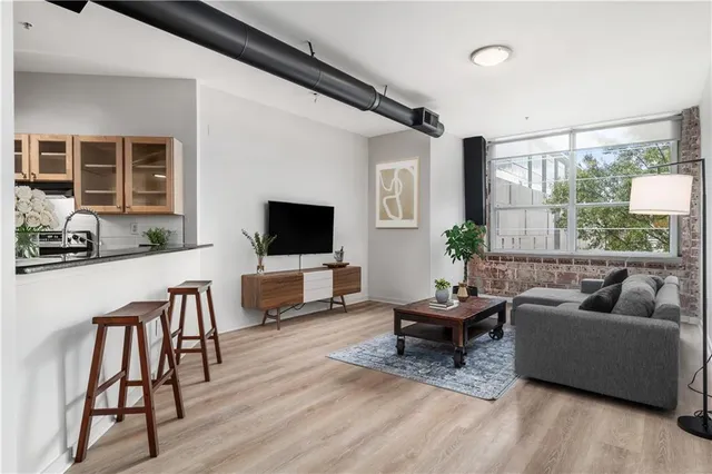 a living room with furniture a flat screen tv and a large window
