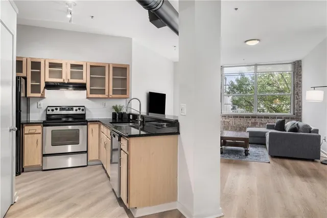 a kitchen with stainless steel appliances kitchen island granite countertop a stove and a sink
