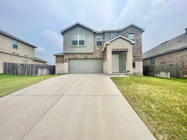 a front view of a house with a yard and garage