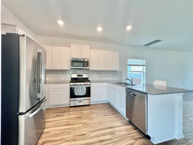 a kitchen with stainless steel appliances a refrigerator stove microwave and sink