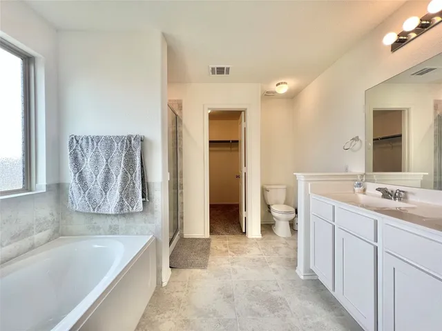 a bathroom with a tub a sink and a large mirror