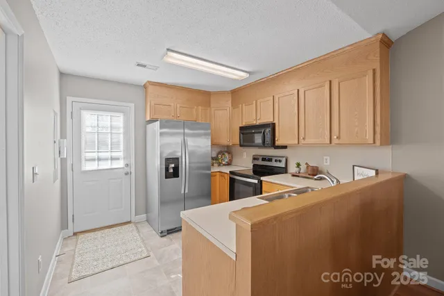 a kitchen with stainless steel appliances a refrigerator sink and microwave