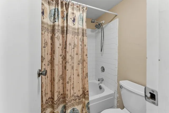 a bathroom with a shower curtain and a toilet