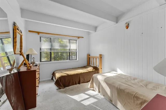 a bedroom with two beds and windows