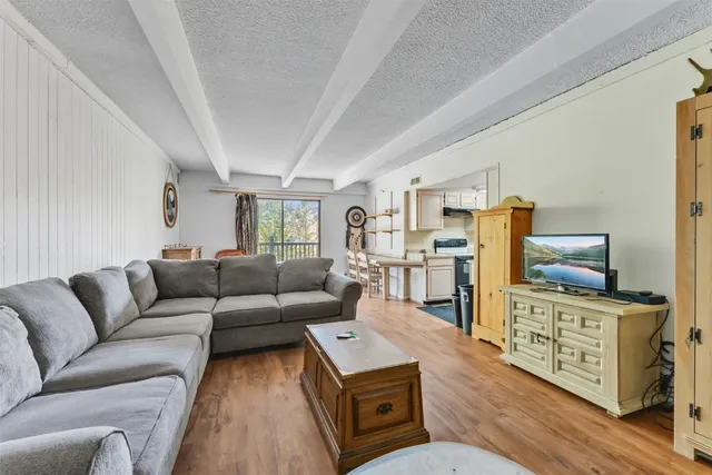 a living room with furniture a flat screen tv and a rug