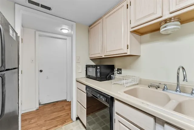a kitchen with stainless steel appliances granite countertop a sink and dishwasher with white cabinets