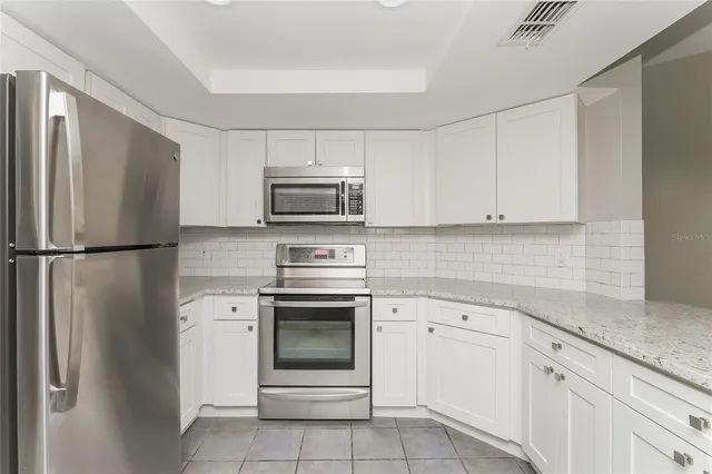 a kitchen with white cabinets stainless steel appliances and sink