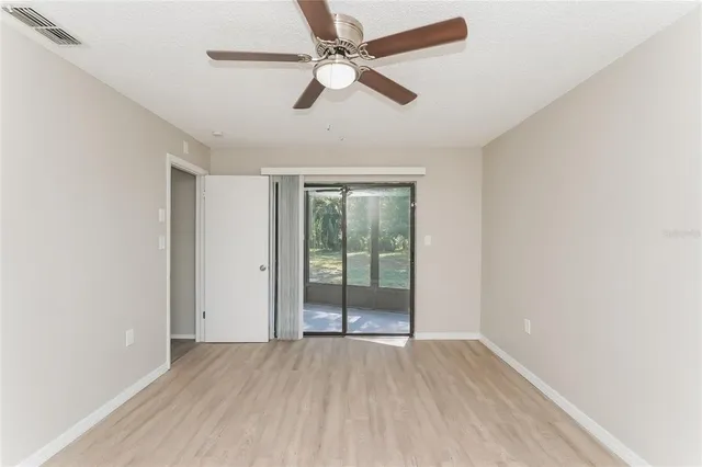 an empty room with fan and windows