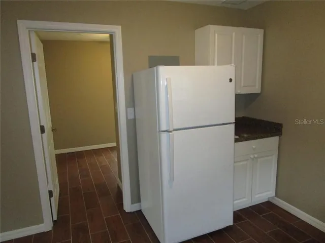 a white refrigerator freezer and a stove sitting inside of a kitchen