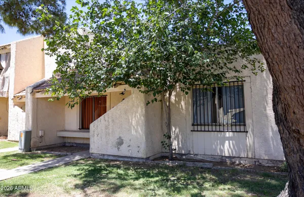 a view of house with backyard and a tree