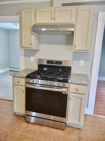 a stove top oven sitting inside of a kitchen