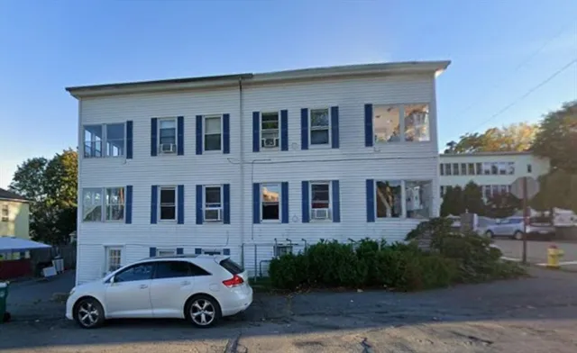 a car parked in front of a white house