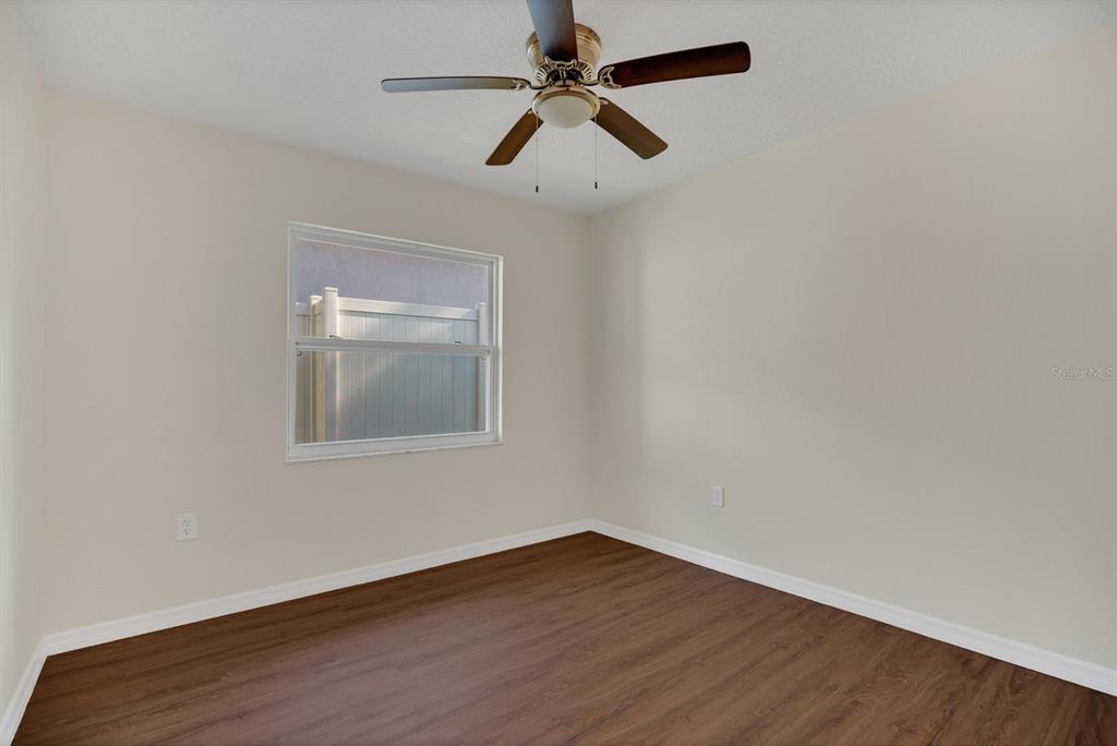 5357 Sunrise Boulevard Orlando, FL 32803 - Photo 18 of 26 an empty room with wooden floor chandelier fan and windows