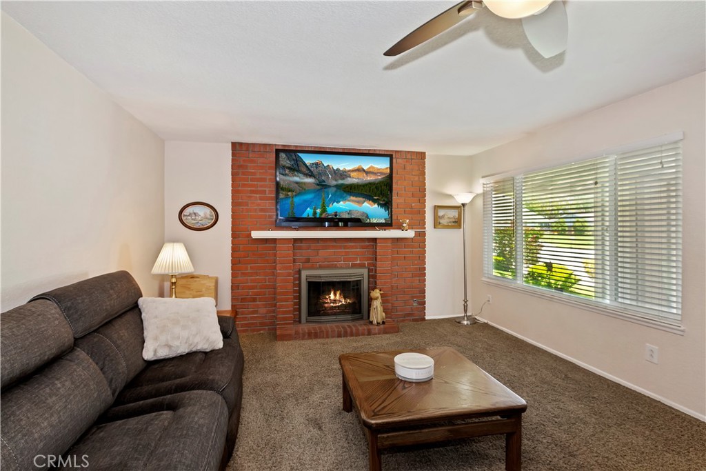 8527 Hillside Road Rancho Cucamonga, CA 91701 - Photo 8 of 50 a living room with furniture a fireplace and a flat screen tv