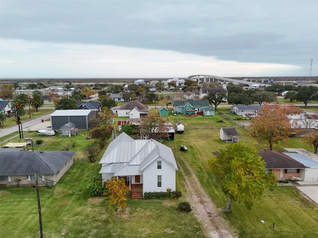 an aerial view of residential houses with outdoor space and trees