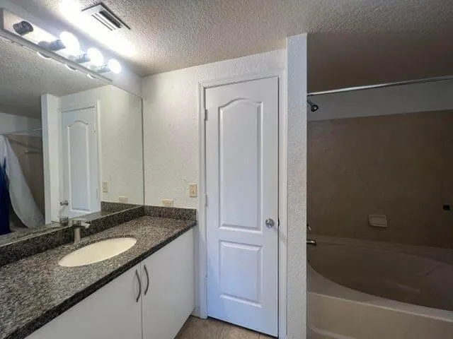 a bathroom with a granite countertop sink and a mirror