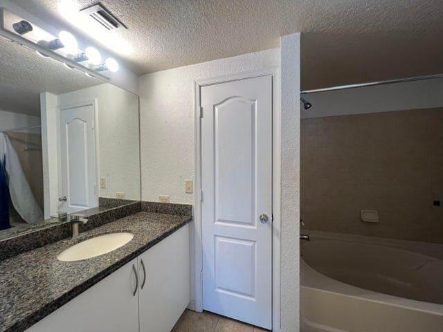 132 Southwest Peacock Boulevard, Unit 17104 Port St. Lucie, FL 34986 - Photo 15 of 28 a bathroom with a granite countertop sink and a mirror