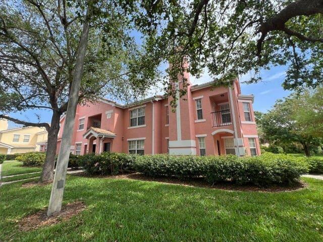 132 Southwest Peacock Boulevard, Unit 17104 Port St. Lucie, FL 34986 - Photo 19 of 28 a front view of a house with a yard