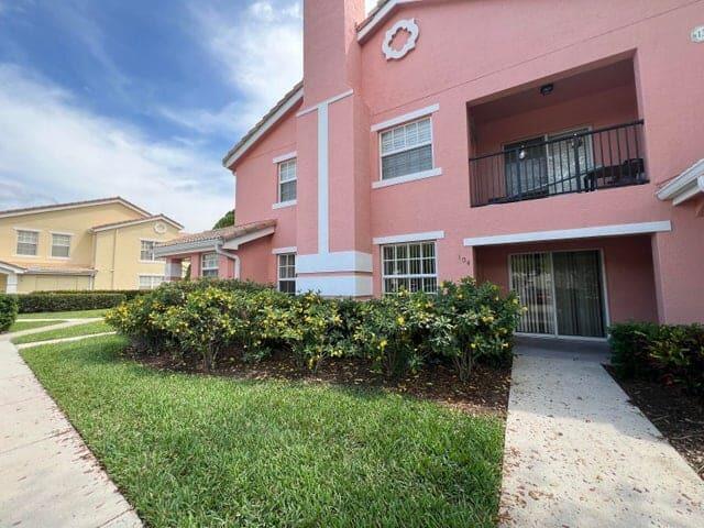 132 Southwest Peacock Boulevard, Unit 17104 Port St. Lucie, FL 34986 - Photo 20 of 28 a front view of a house with garden and porch