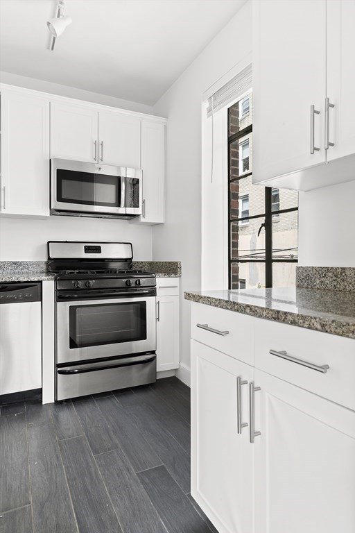 46 Chiswick Road, Unit 7 Boston, MA 02135 - Photo 5 of 16 a kitchen with granite countertop white cabinets and appliances