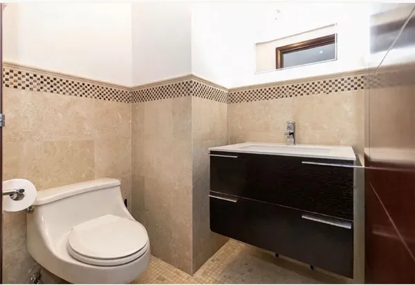 a bathroom with a toilet a sink and mirror