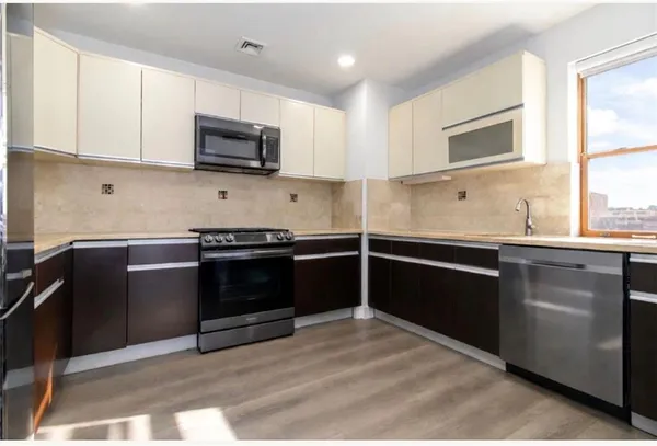 a kitchen with stainless steel appliances granite countertop a stove and a microwave