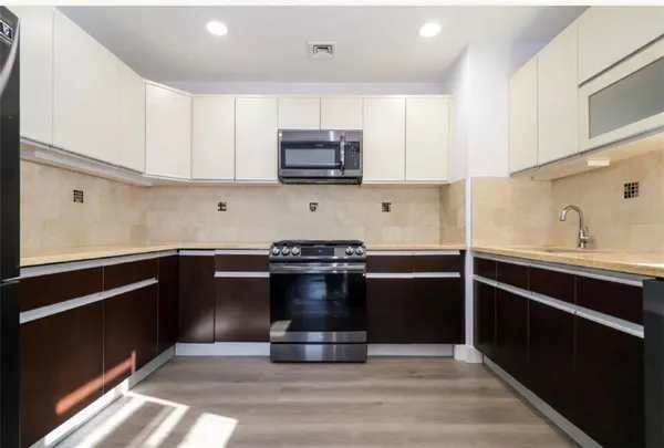 a kitchen with kitchen island granite countertop a stove and a sink