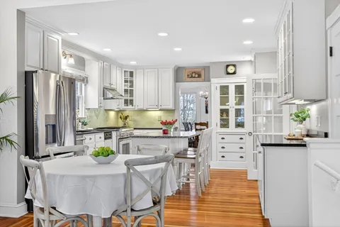 a kitchen with stainless steel appliances kitchen island granite countertop a stove refrigerator and cabinets