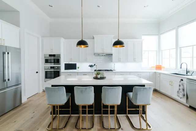 a kitchen with a dining table chairs and white cabinets
