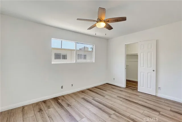 a view of a room with wooden floor and a ceiling fan